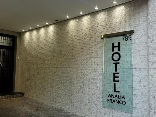 a sign on the side of a brick wall at Hotel Anália Franco in Sao Paulo