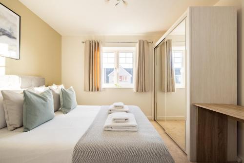 a bedroom with a large white bed with a window at The Morden Collection in London