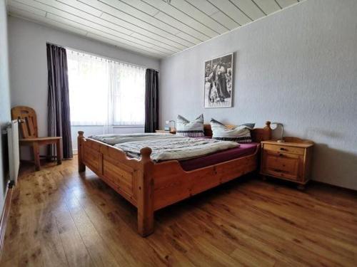 a bedroom with a large wooden bed and a window at Ferienwohnung-Kornkammer in Presen