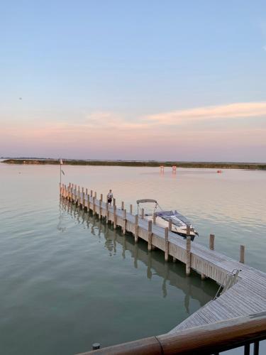a person standing on a dock in the water at Seehütte Neusiedlersee - Seehaus inklusive Elektroboot in Rust