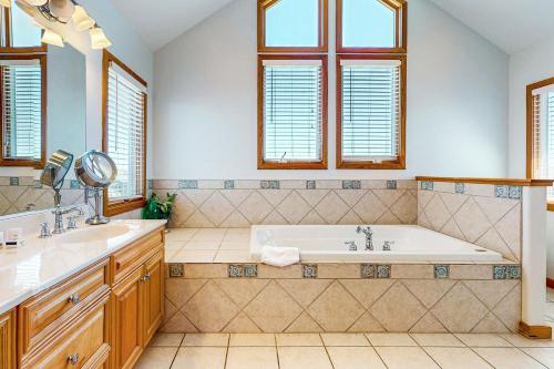 a bathroom with a tub and two sinks and windows at Lapha Amanzi #6-PA in Avon