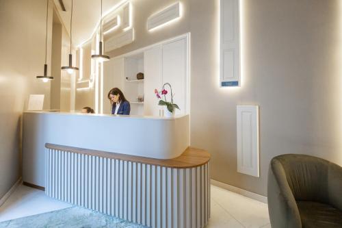 a woman standing behind a counter in a room at Avenida Boutique Hotel in Viseu