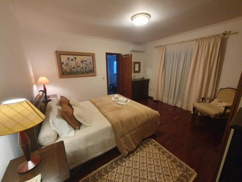 Casa da Bela Vista في Casal de Loivos: غرفة نوم بسرير ومصباح وكرسي