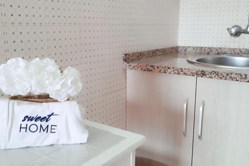 - une cuisine avec un évier et un sac blanc sur un comptoir dans l'établissement Sweet Home Casa dos Arcos 409, à Portimão