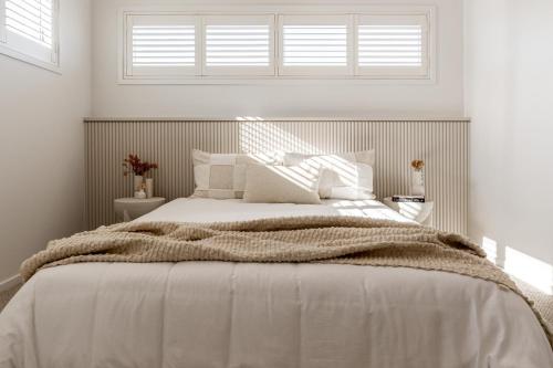 a white bedroom with a large bed with a window at Cream Elegance Brand new Luxury 5BR Ex Display Home in Bahrs Scrub