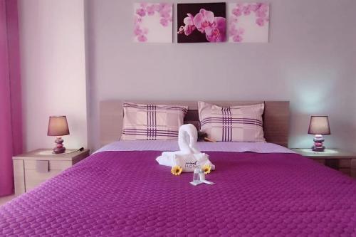 un poulet jouet assis sur un lit violet dans l'établissement Sweet Home Casa dos Arcos 409, à Portimão