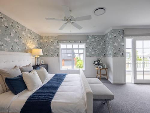 1 dormitorio con 1 cama grande y ventilador de techo en Stunning Luxurious 4 Bedroom Mansion Rochedale, en Rochedale