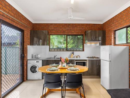 a kitchen with a table and a white refrigerator at 1 Bedroom Comfy Unit Sleep 3 close to mall and bus in Brisbane