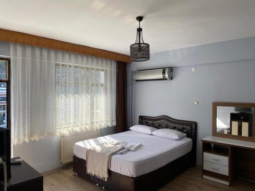 een slaapkamer met een groot bed en een spiegel bij TRABZON FEYZAN OTEL in Trabzon