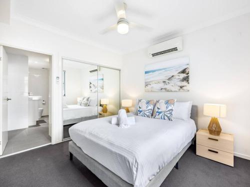 - une chambre blanche avec un grand lit et une salle de bains dans l'établissement Chic Modern Retreat 1BR Apt w pool Kelvin Grove, à Brisbane