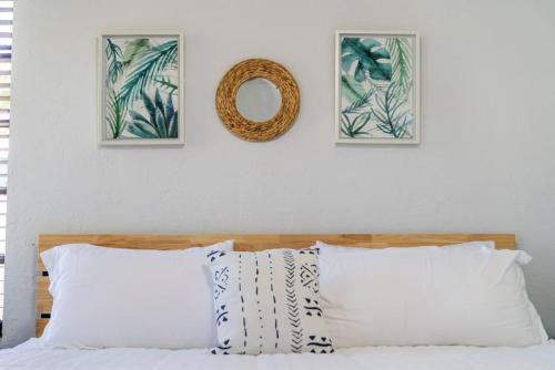 a bedroom with a bed with three pictures on the wall at Hidden Gem Off Atlantic Ave, Just Steps From Beach in Delray Beach
