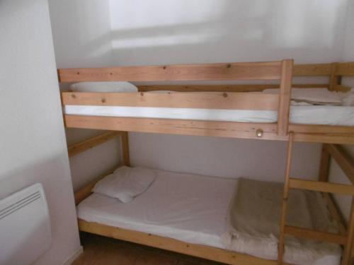 une chambre avec deux lits superposés dans une pièce dans l'établissement HOLIDAYLAND 302 VILLA T3 MEZZANINE 8 couchages climatisé NARBONNE PLAGE, à Narbonne-Plage