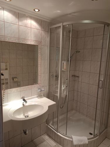 a bathroom with a shower and a sink at Hotel Grünwaldkopf in Obertauern
