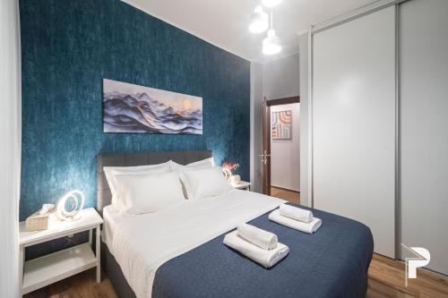 ein Schlafzimmer mit einem großen Bett mit blauer Wand in der Unterkunft P deluxe suites 4 in Thessaloniki