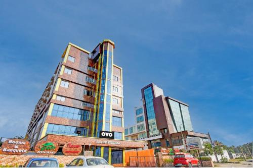 two tall buildings with cars parked in front of them at Collection O by OYO Flavour in Āsansol