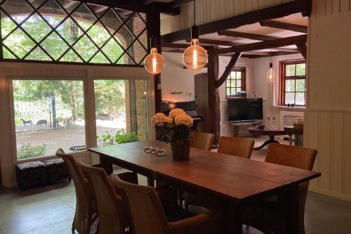 een eetkamer met een houten tafel en stoelen bij Gezellige vakantieboerderij voor 14 personen in De Lutte