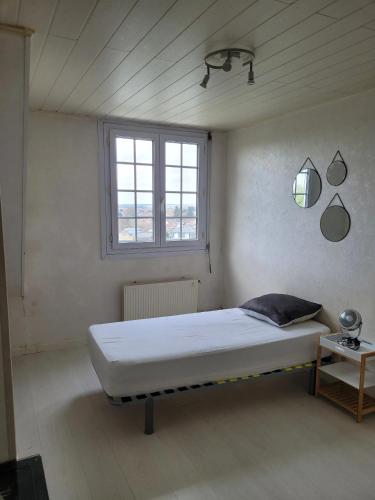 een bed in een kamer met een raam bij Maison de 5 chambres avec jardin clos et wifi a Dammartin en Goele in Dammartin-en-Goële