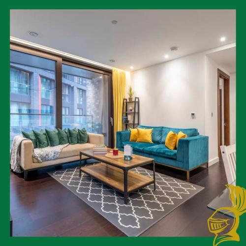 a living room with a blue couch and a table at The Embassy Suite Two Bedrooms Devereux Residences in London