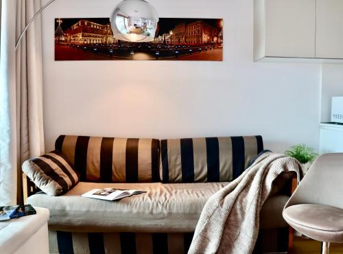 a living room with a couch and a picture on the wall at Portopiccolo Apartments - Loggia sul mare in Sistiana
