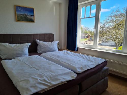 a bed in a bedroom with a large window at Doppelhaushaelfte-Klatschmohn in Presen