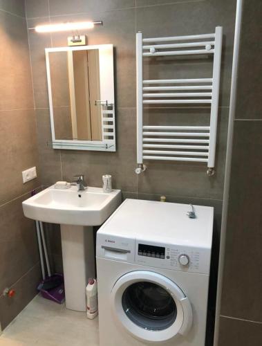 a bathroom with a washing machine and a sink at Bakuriani Park Recidence Apartment in Bakuriani