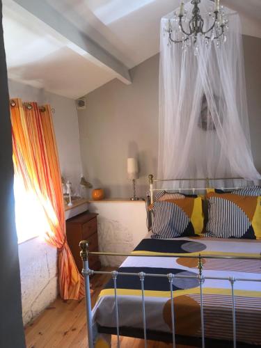 une chambre avec un lit à baldaquin dans l'établissement La Bergerie, à Lauroux