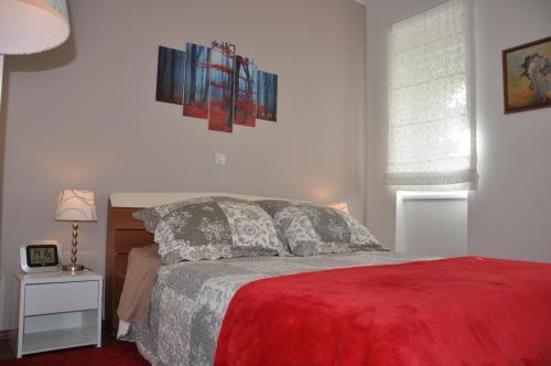 a bedroom with a bed with a red blanket at Apartments Sulekova in Zagreb