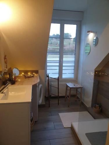 une petite salle de bain avec un lavabo et une fenêtre dans l'établissement Bel appartement 4 personnes, à Port-en-Bessin-Huppain