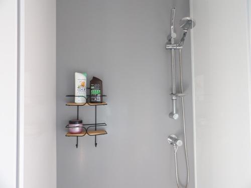 a shower door with a shelf with products on it at St Cyprien Mobil home 6 personnes Linge inclus in Saint-Cyprien