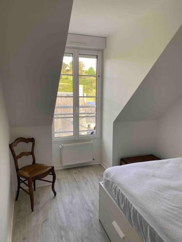 une chambre avec un lit, une chaise et une fenêtre dans l'établissement Bel appartement 4 personnes, à Port-en-Bessin-Huppain