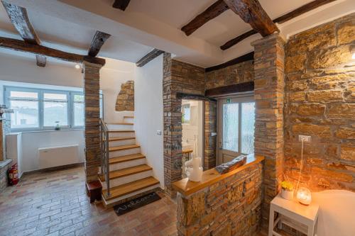 a room with brick walls and a staircase in a house at Holiday Home Belveder Motovun with heated pool in Livade