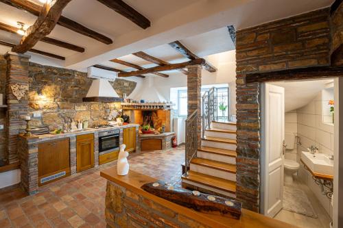 a large kitchen with stone walls and a staircase at Holiday Home Belveder Motovun with heated pool in Livade