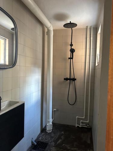 een douche in de badkamer met een wastafel en een douche bij Nordic Design Residency / Natural habitat in Kopenhagen