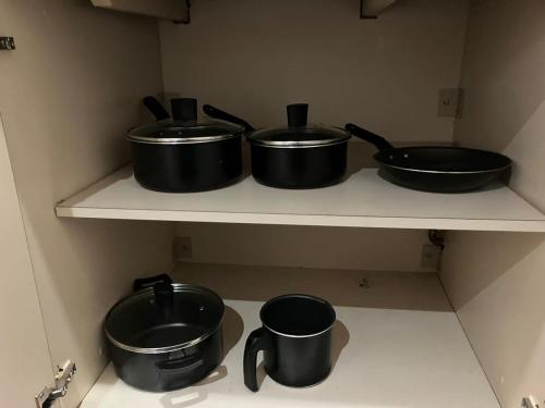 three pots and pans sitting on a shelf in a kitchen at Apart Hotel Volpi 101 - Conforto & Comodidade in Belo Horizonte