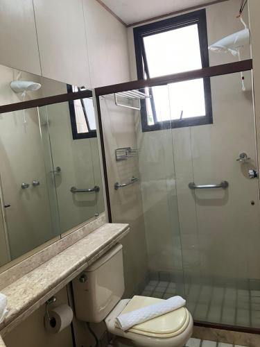 a bathroom with a toilet and a glass shower at Apart Hotel Volpi 101 - Conforto & Comodidade in Belo Horizonte