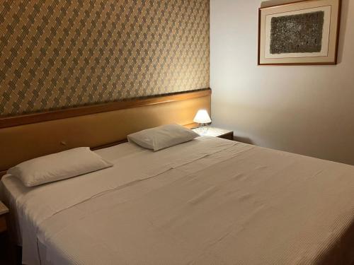 a bedroom with a large white bed in a room at Apart Hotel Volpi 101 - Conforto & Comodidade in Belo Horizonte