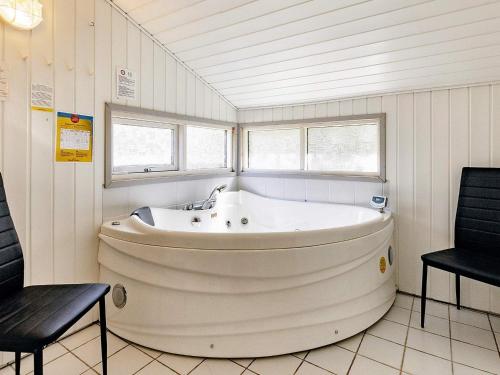 Ålbækにある8 person holiday home in lb kのバスルーム(大きな白いバスタブ、椅子2脚付)