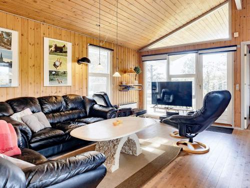 Ålbækにある8 person holiday home in lb kのリビングルーム(革張りのソファ、テーブル付)