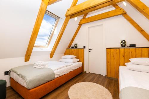 - une chambre mansardée avec 2 lits et une fenêtre dans l'établissement House Vuk, à Kupjak