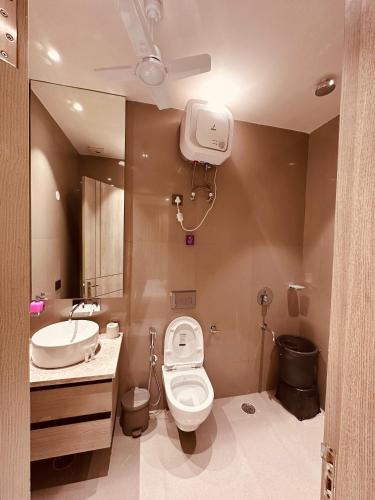 a bathroom with a toilet and a sink at The Lodgers 2 BHK Serviced Apartment Near Artemis Hospital Sector 57 Gurgaon - Nearest Metro Station Sector 54 Chowk in Gurgaon