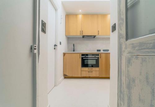 - une cuisine avec des placards en bois et une cuisinière dans l'établissement Superbe appartement centre de Biarritz, à Biarritz