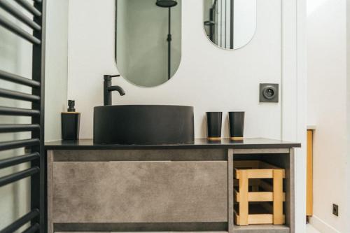 une salle de bain avec un lavabo et un miroir dans l'établissement Superbe appartement centre de Biarritz, à Biarritz