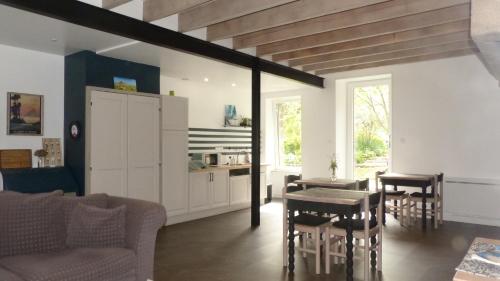 a living room with a table and chairs and a kitchen at Maison d'hôtes KerCalow, Chambres d'hôtes in Pleine-Fougères