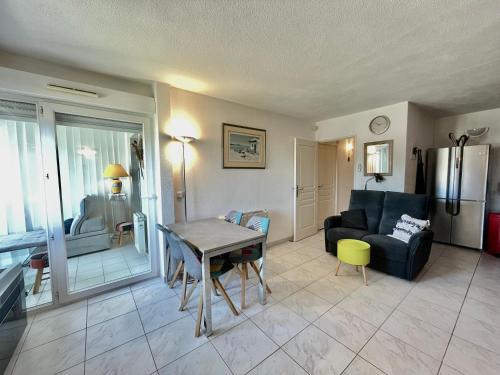 un salon avec une table et un canapé dans l'établissement PGH N16 - à Deux Pas du Golf avec Parking Privé, à La Grande Motte