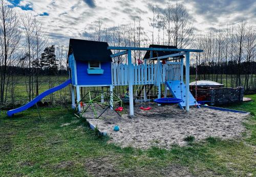 einen Spielplatz mit Rutsche und Spielstruktur in der Unterkunft Domki na Mazurach - Marksewo in Szczytno