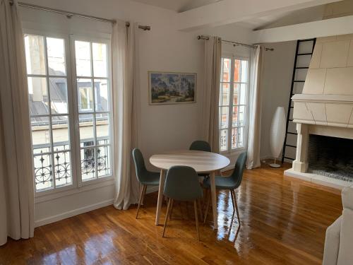 a dining room with a table and chairs and a fireplace at VUE SUR LA SEINE in Paris