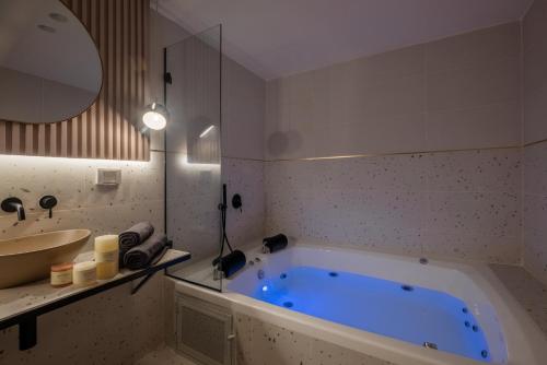 uma casa de banho com uma banheira azul e um lavatório. em jacuzzi apartment em Jerusalém