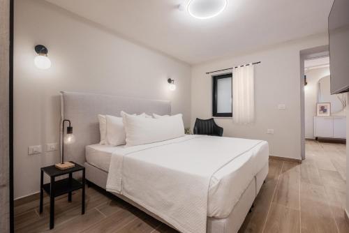 um quarto branco com uma cama grande e uma mesa em jacuzzi apartment em Jerusalém