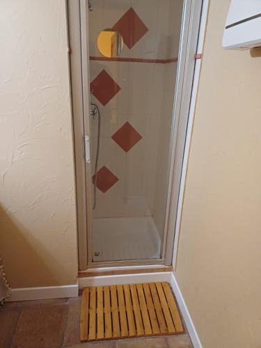 a shower with a glass door with a wooden floor at Chambre d hôte Lavande "Au fond du jardin" in Saint-Saturnin-lès-Avignon