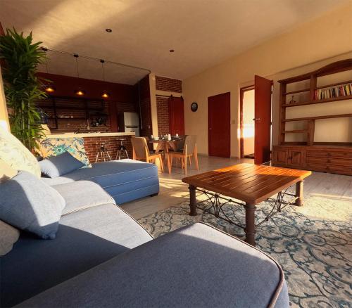 una sala de estar con sofás azules y una mesa. en Residencial Aéreo Albatros en Tequesquitengo